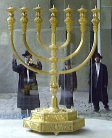 Three Hasidic Jews look upon a Menorah Replica